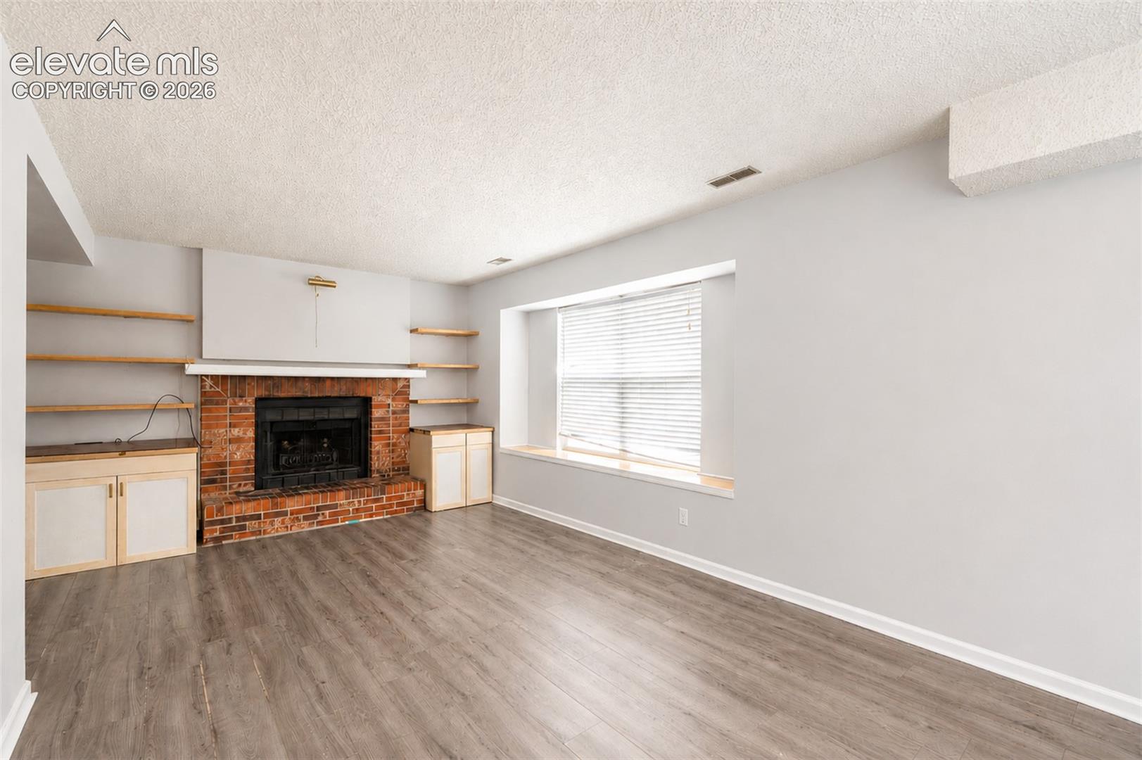 Family Room with Window to Backyard and Fireplace.
