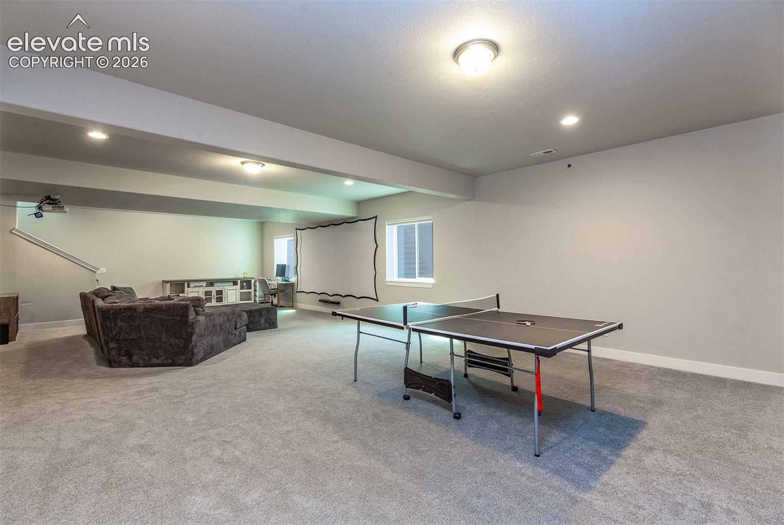 Spacious lower level featuring carpeted flooring, recessed lighting, built-in shelving, and multiple windows