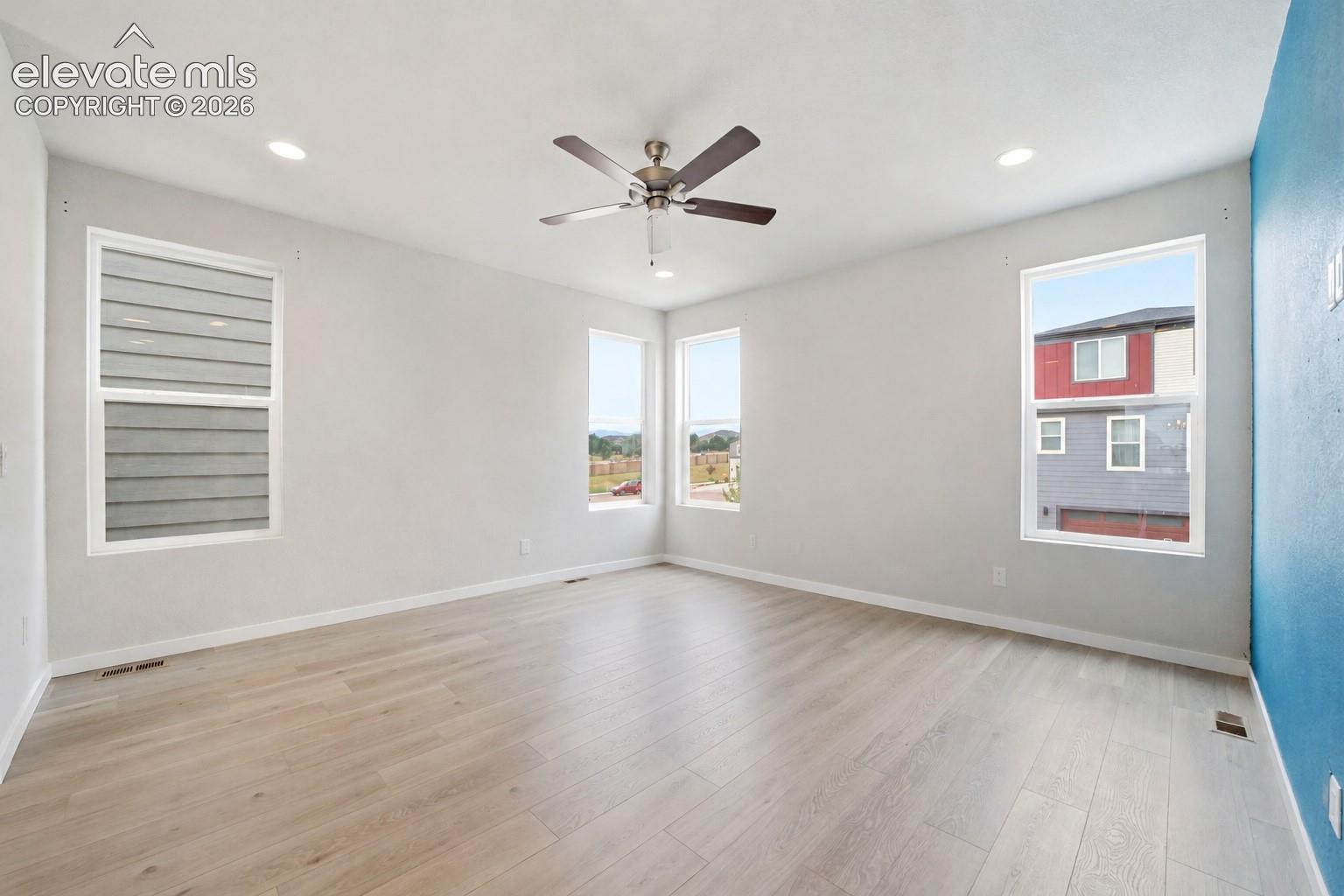 Recessed lighting, ceiling fan, multiple windows, light-toned walls, and wood-finish flooring