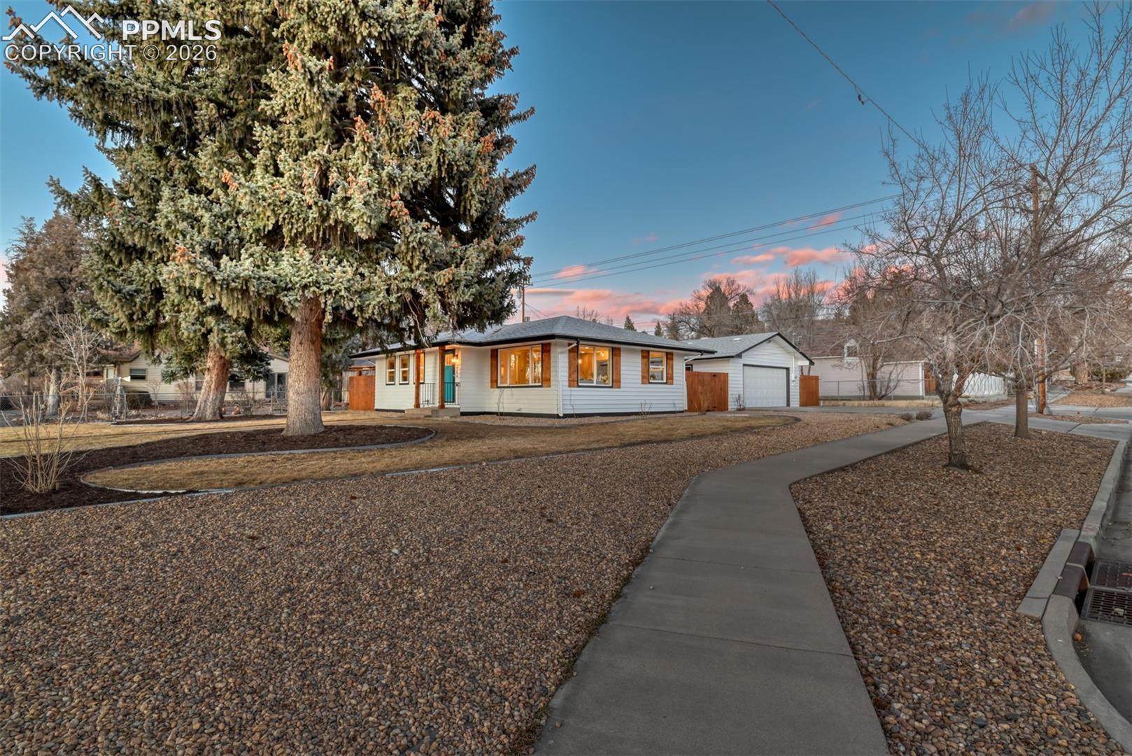 Ranch-style home with a garage and an outbuilding