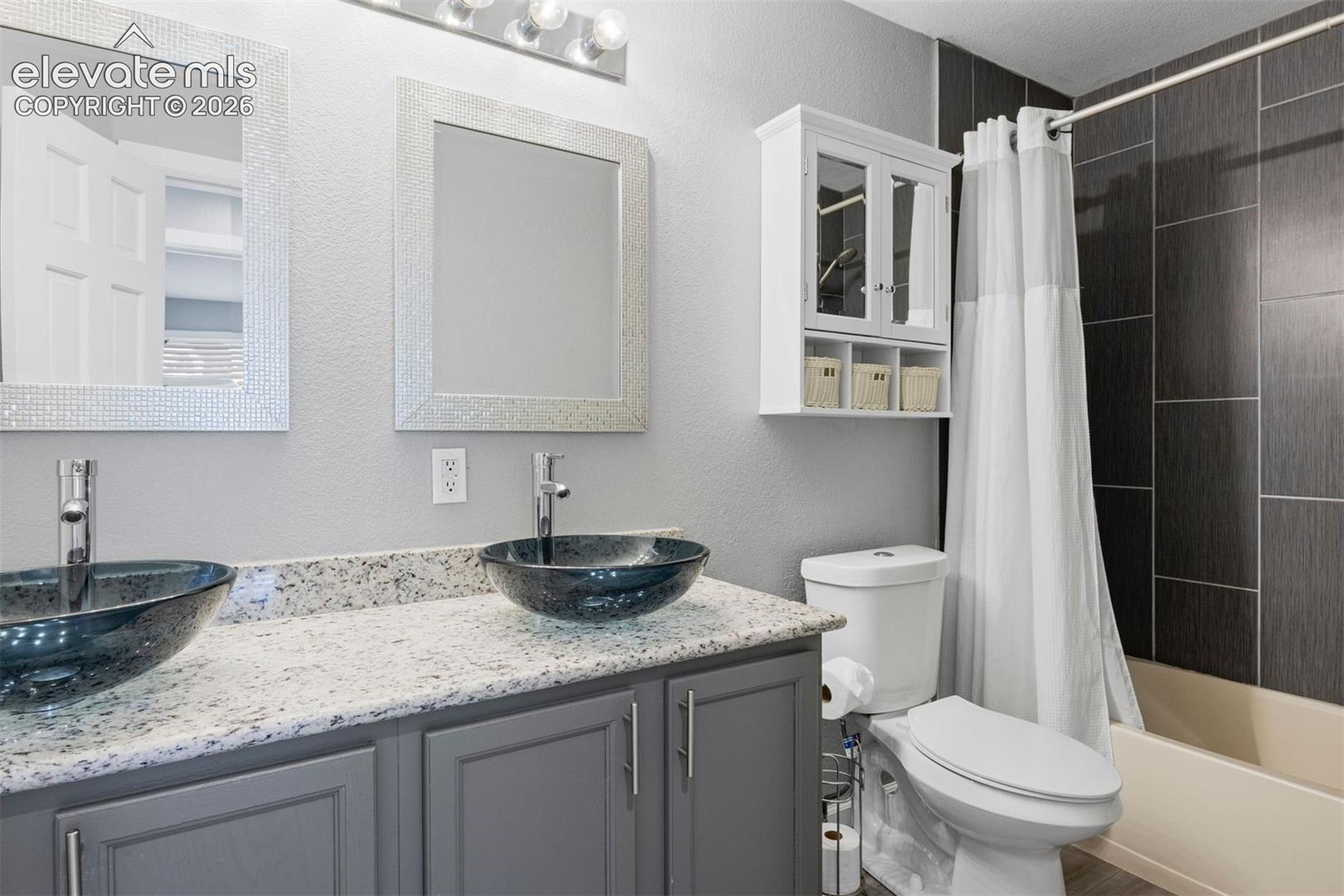 Upstairs bathroom. Dual vessel sinks with modern chrome faucets set on a stone countertop