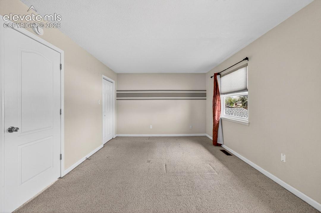 Neutral wall paint with accent stripe, white trim, and a window providing natural illumination