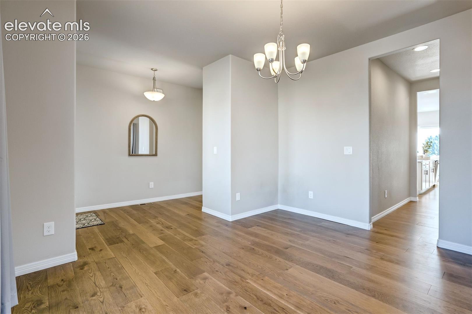Wood-finish flooring, recessed lighting, and a modern chandelier