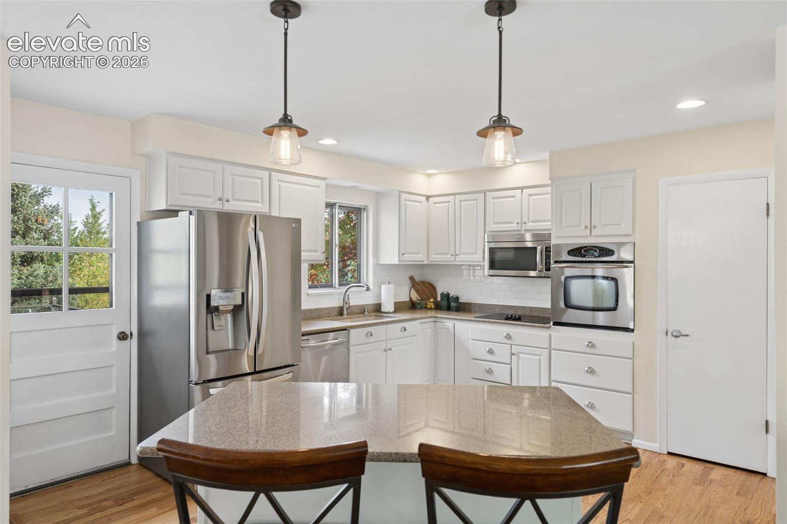 Kitchen features newer appliances and lights with the pantry on the right, 