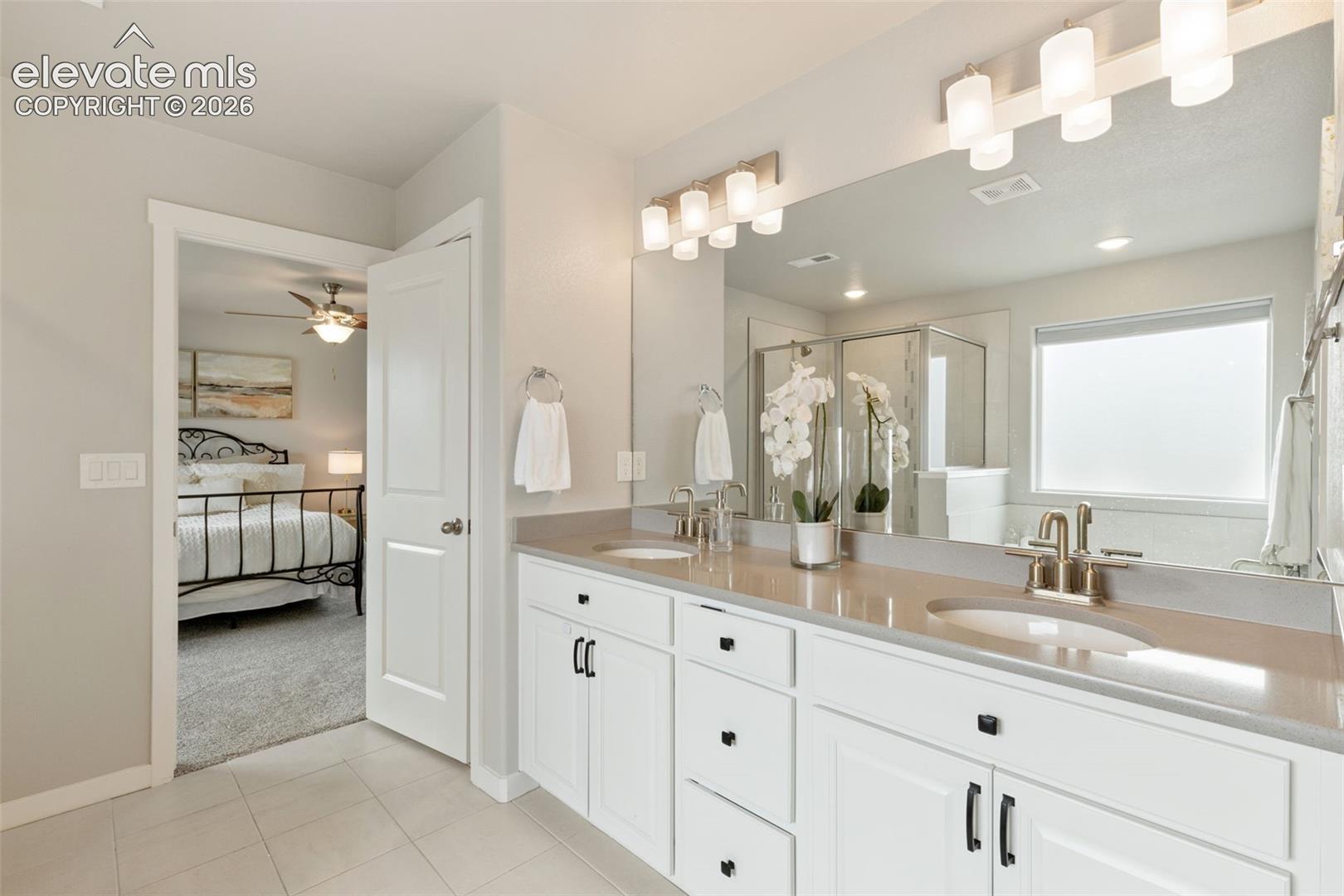 Dual vanity with white cabinetry, light-toned countertop, and undermount sinks