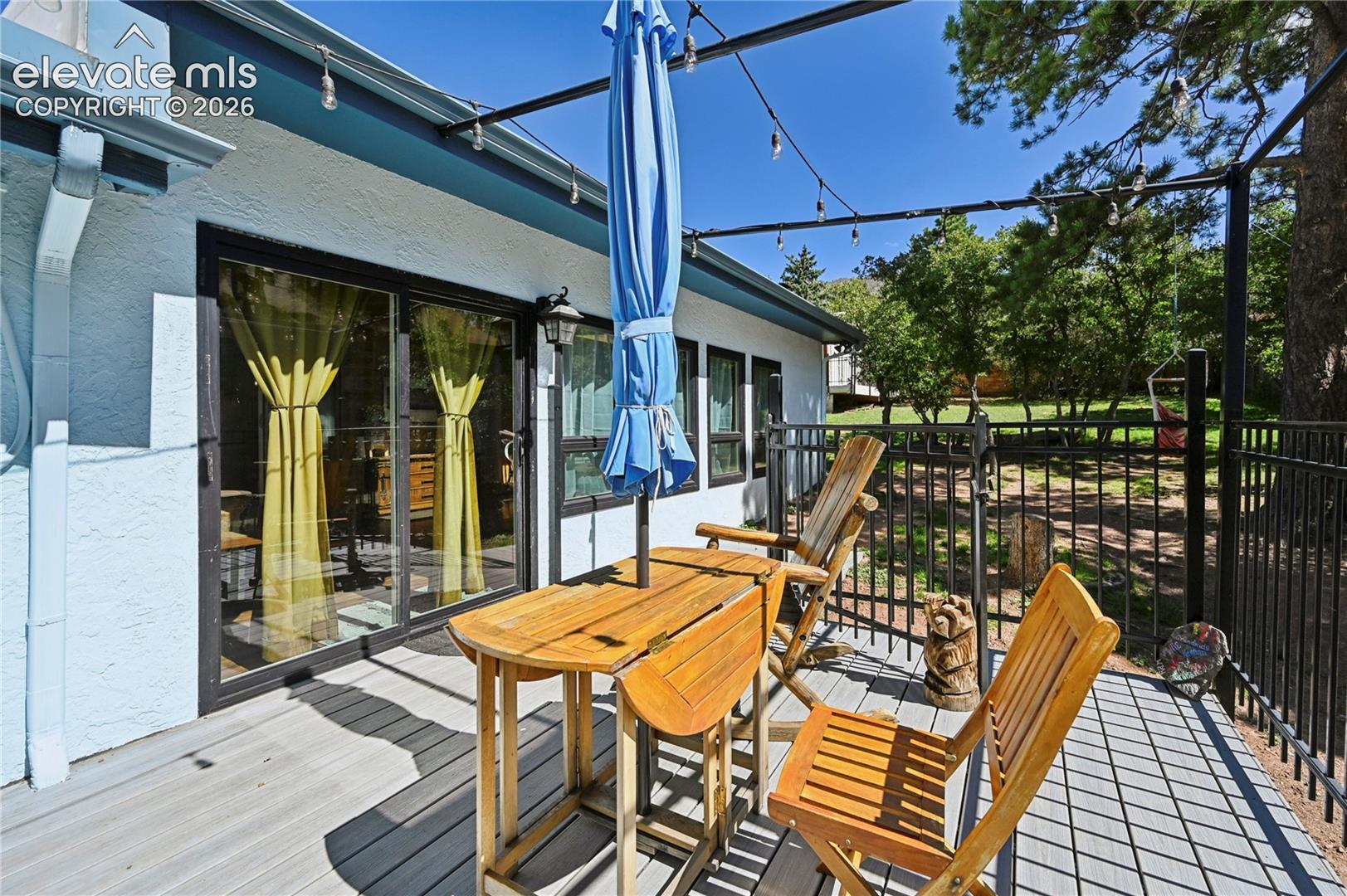 Deck with composite decking, black metal railing, and string lighting