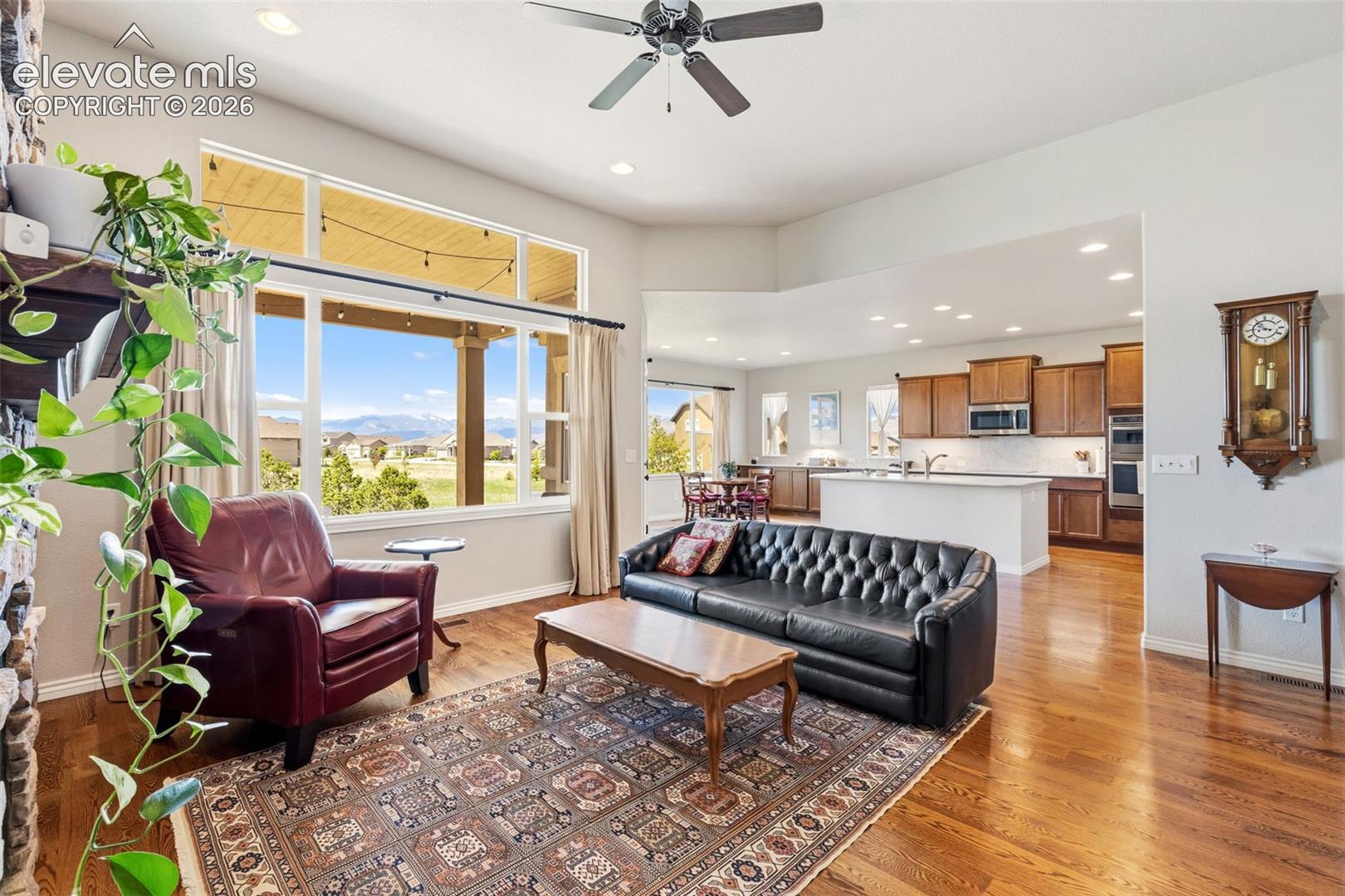 Open floor plan of living room, kitchen and eat-in area featuring mountain views, hardwood flooring and 13' ceilings