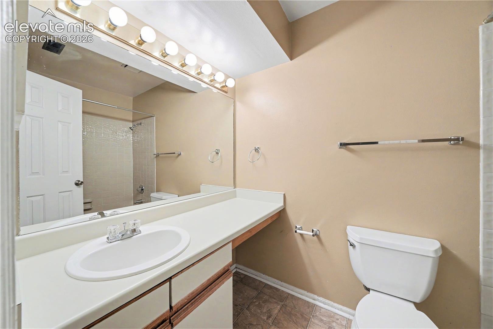 Bathroom with laminate vanity and tiled tub shower