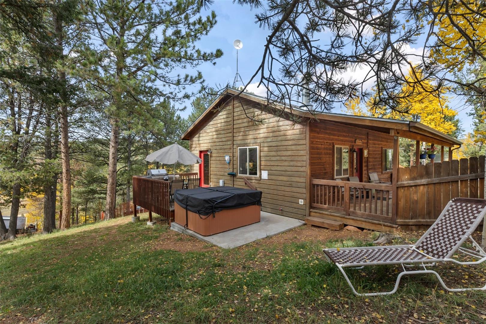 Wood-sided exterior with a sloped roofline, featuring a covered deck and an additional open-air deck