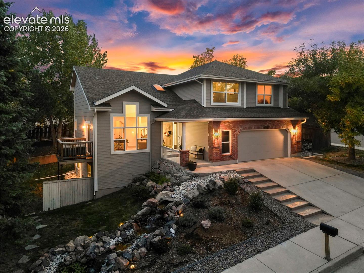 Two-story residence with a multi-level architectural design, attached garage, and stone and siding exterior