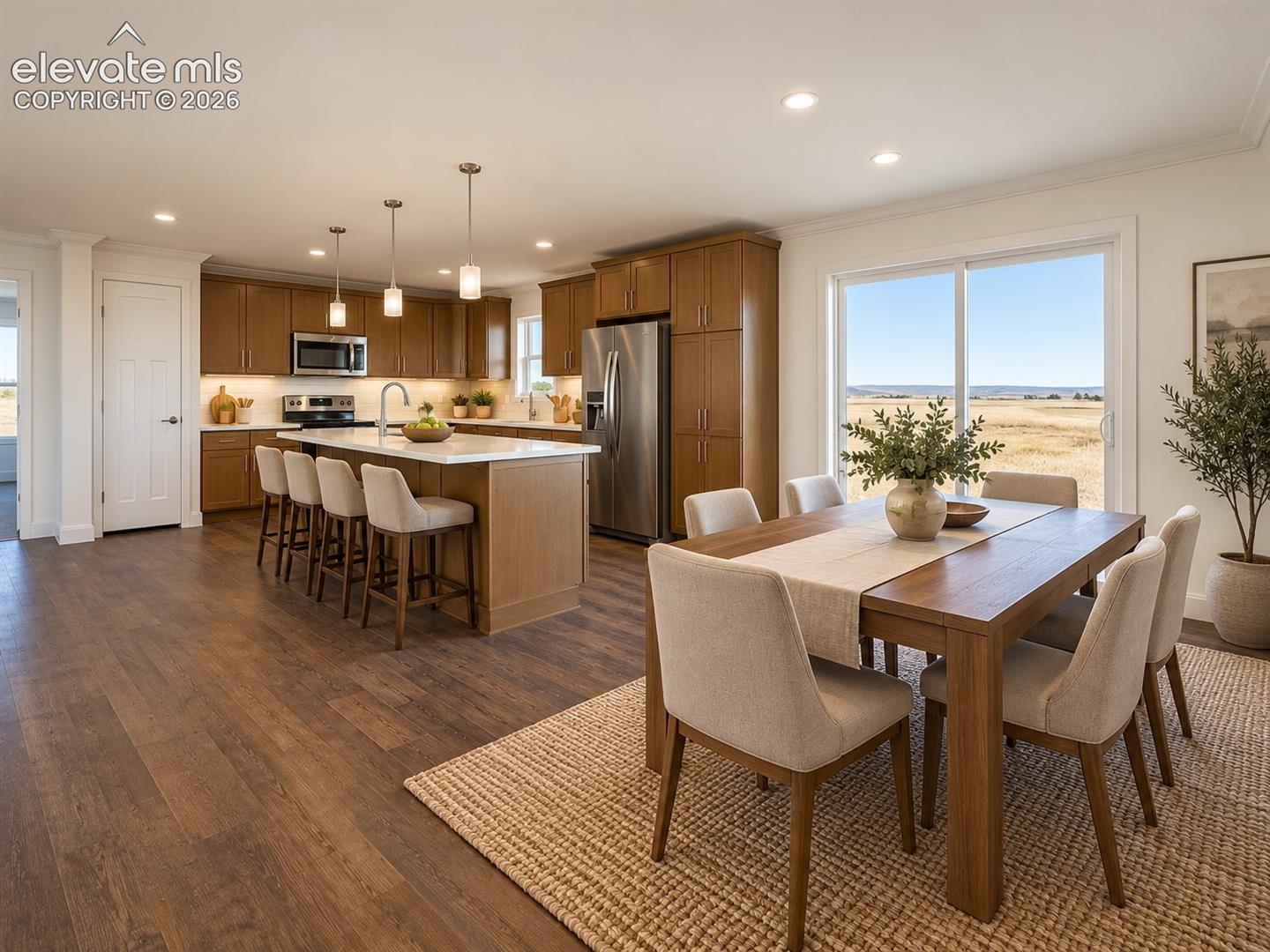 Kitchen & Dining Area – Open kitchen and dining area pairs warm cabinetry and a large center island with stainless steel appliances and a sliding glass door that brings in abundant natural light.