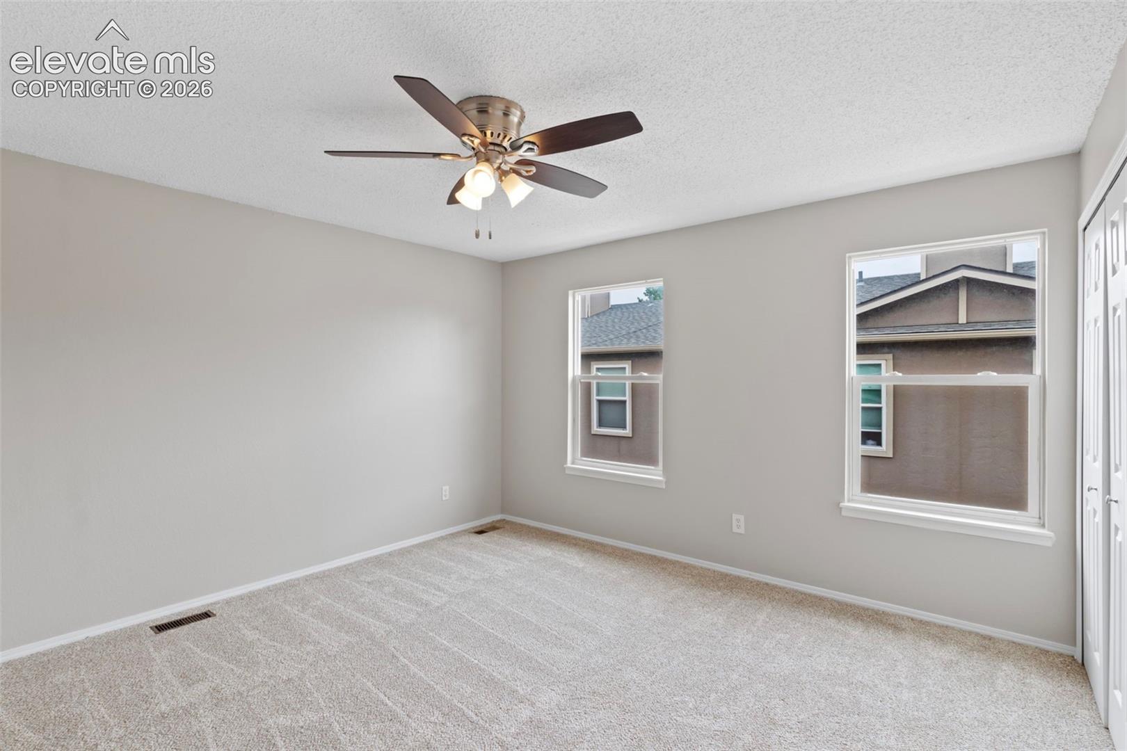 The spacious primary bedroom features abundant natural light and a double closet
