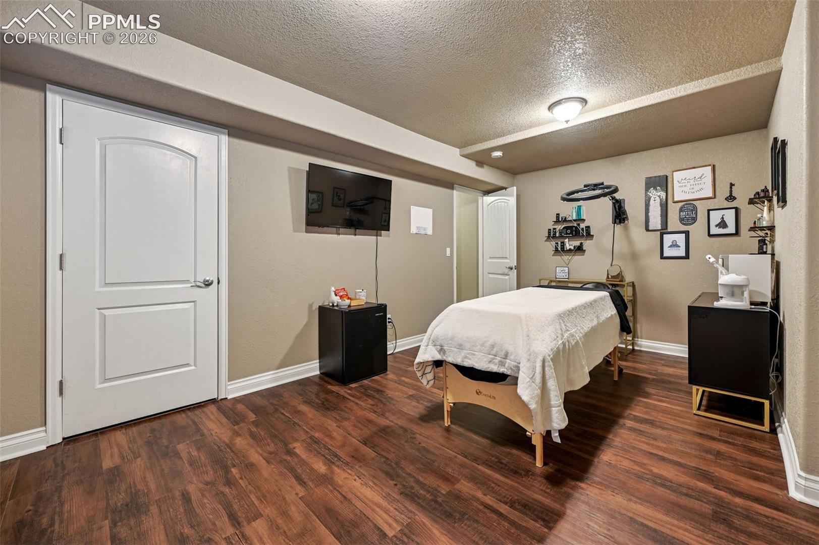 Bedroom featuring a textured ceiling and dark wood-style floors