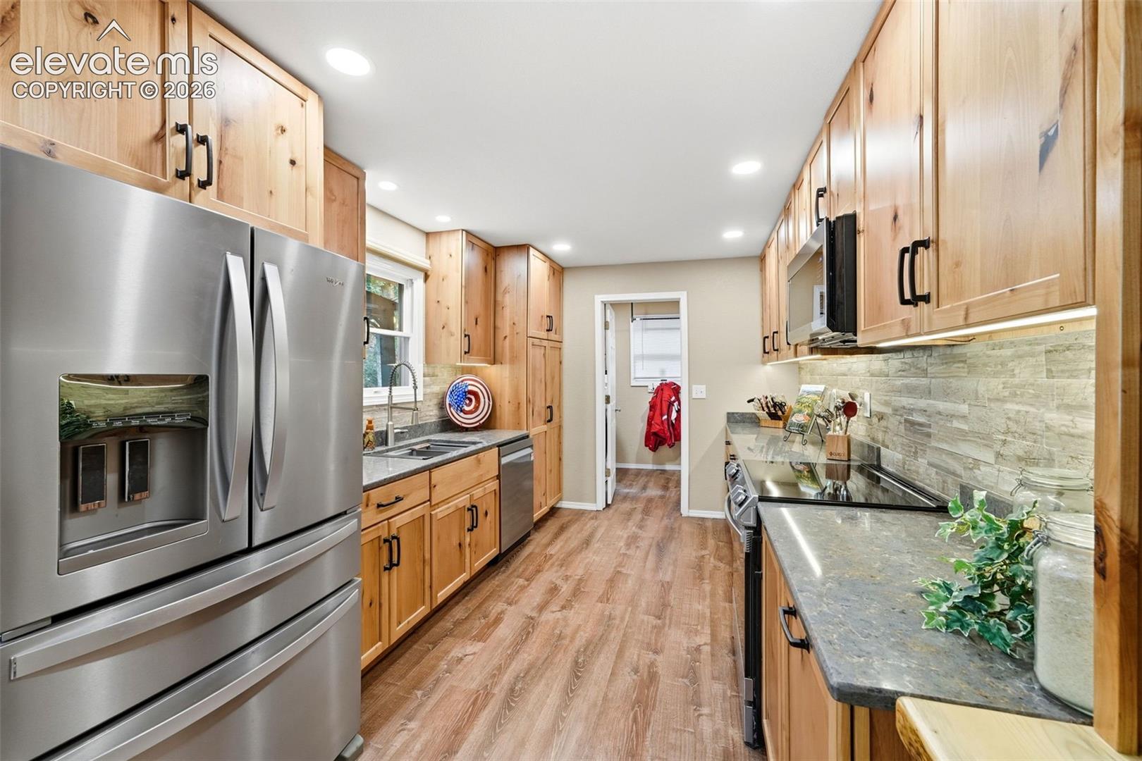 Completely remodeled kitchen, stainless steel appliances, LVP flooring, stone-finish countertops, and alder cabinetry.