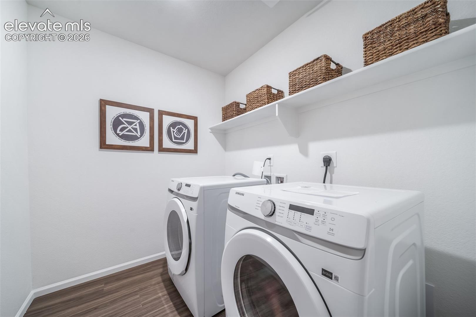 Dedicated laundry area with wood-finish flooring, white walls, and built-in white shelving
*photos of a model home*