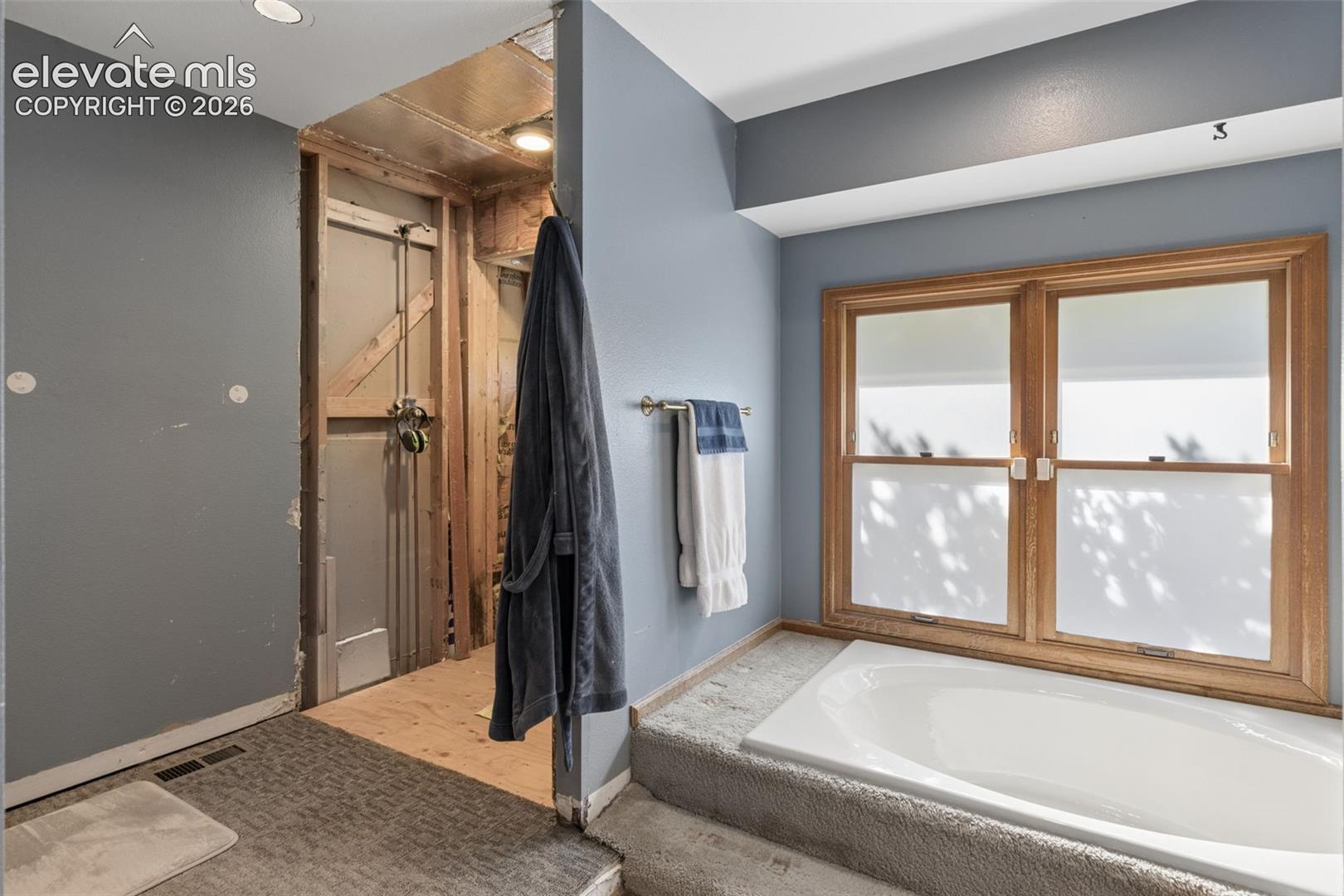Built-in soaking tub with a wood-framed window surround
