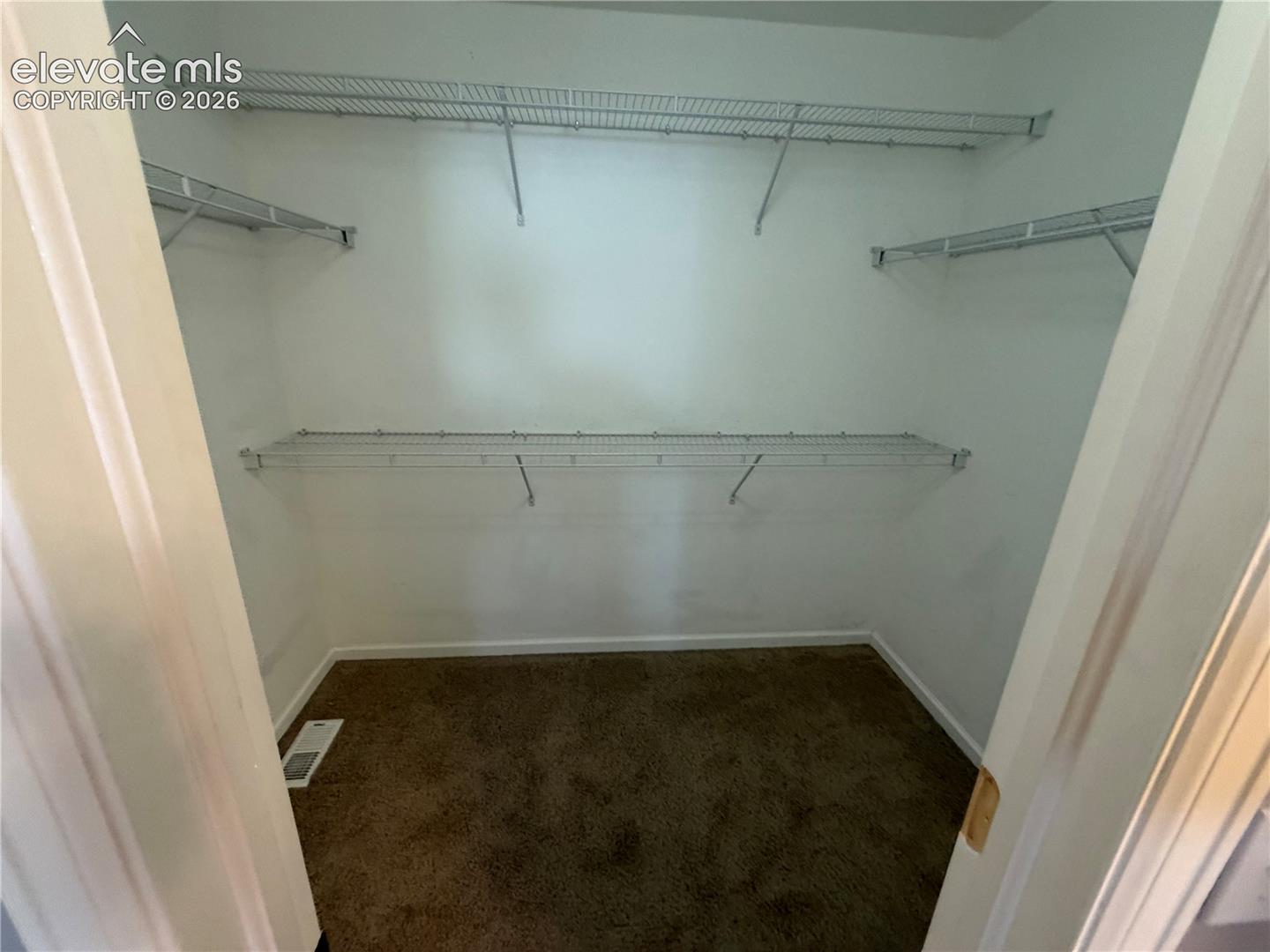 Wall-to-wall carpeting with multiple wire shelving units