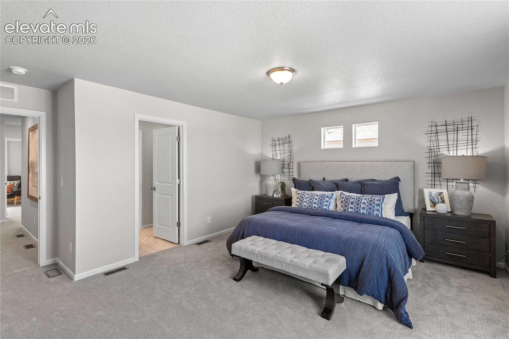 Neutral-toned interior featuring wall-to-wall carpeting, high-profile ceiling lighting, and dual inset windows
*photos of a model home*