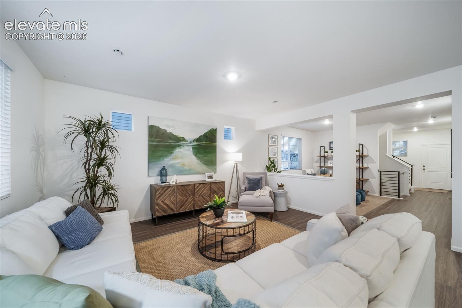 Open-concept living space featuring wood-finish flooring, recessed lighting, and a built-in partial wall
*photos of a model home*