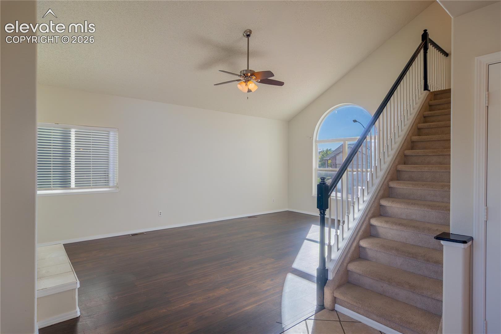 Vaulted ceilings and an oversized arched window fill the living area with natural light.
