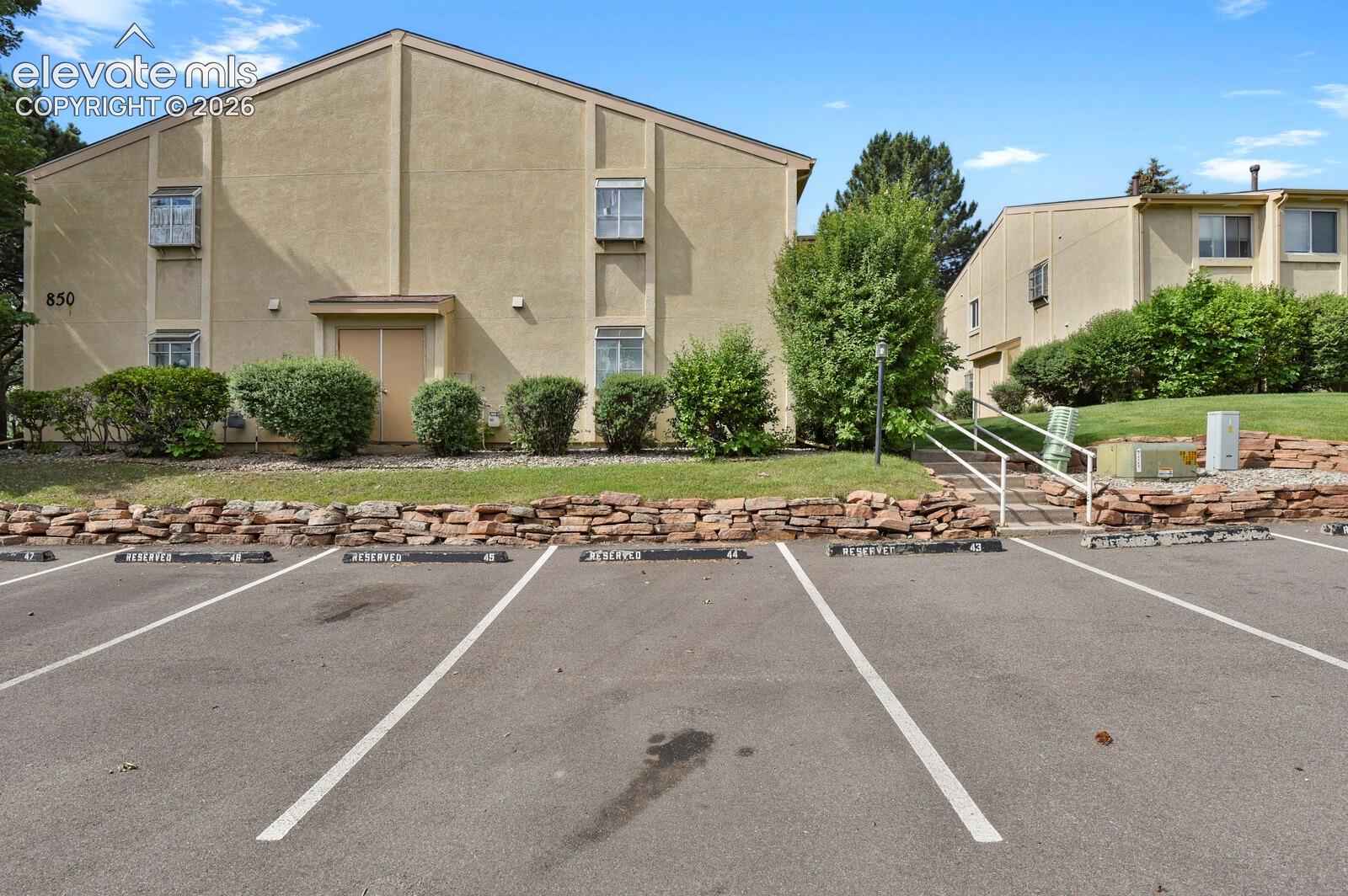 Exterior of building 850, Parking Space #45 and stairway up to the entrance to the condo
