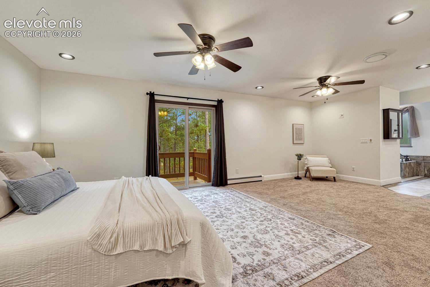 Spacious interior featuring recessed lighting, dual ceiling fans, wall-to-wall carpeting, and a glass sliding door opening to a deck