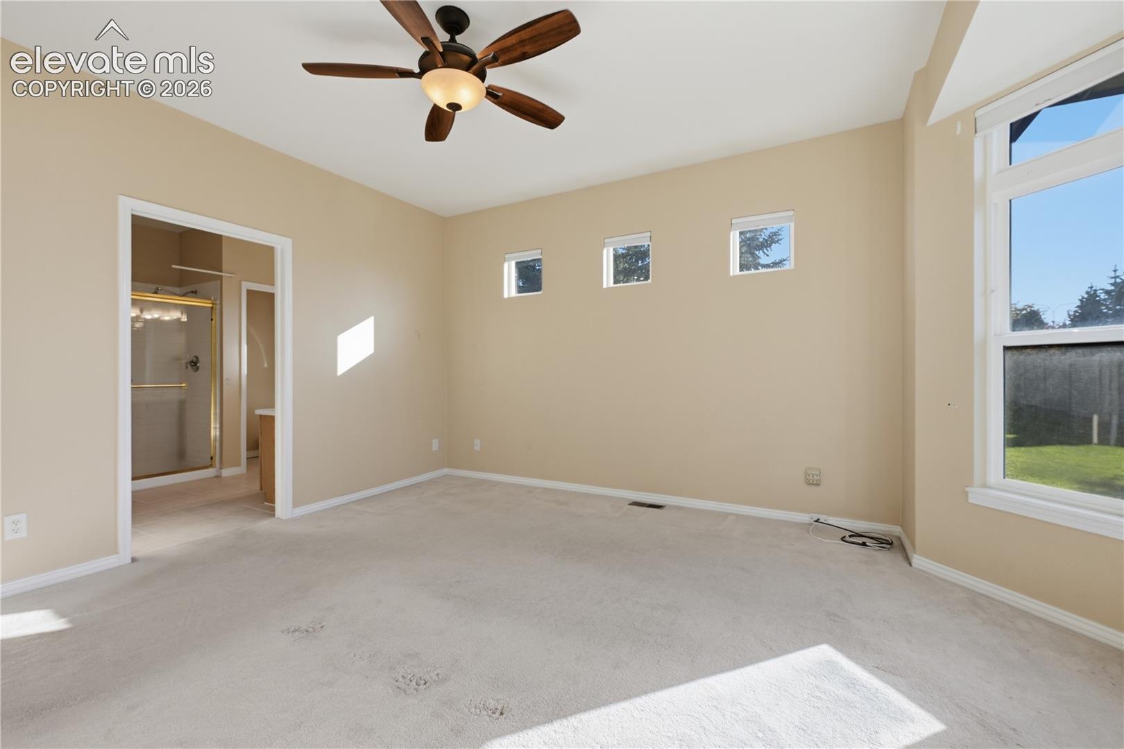 Spacious room featuring a ceiling fan with integrated lighting, a bay window, and three clerestory windows