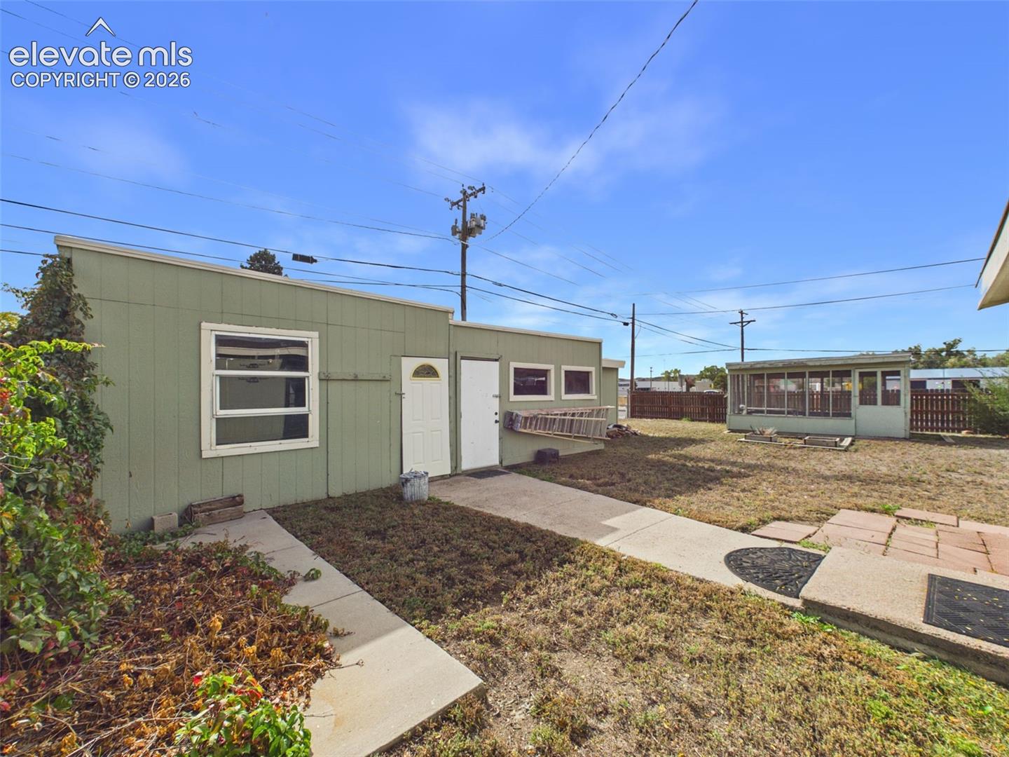 Exterior view of the detached workshop and storage buildings, providing additional space for tools, equipment, projects, and recreational gear.