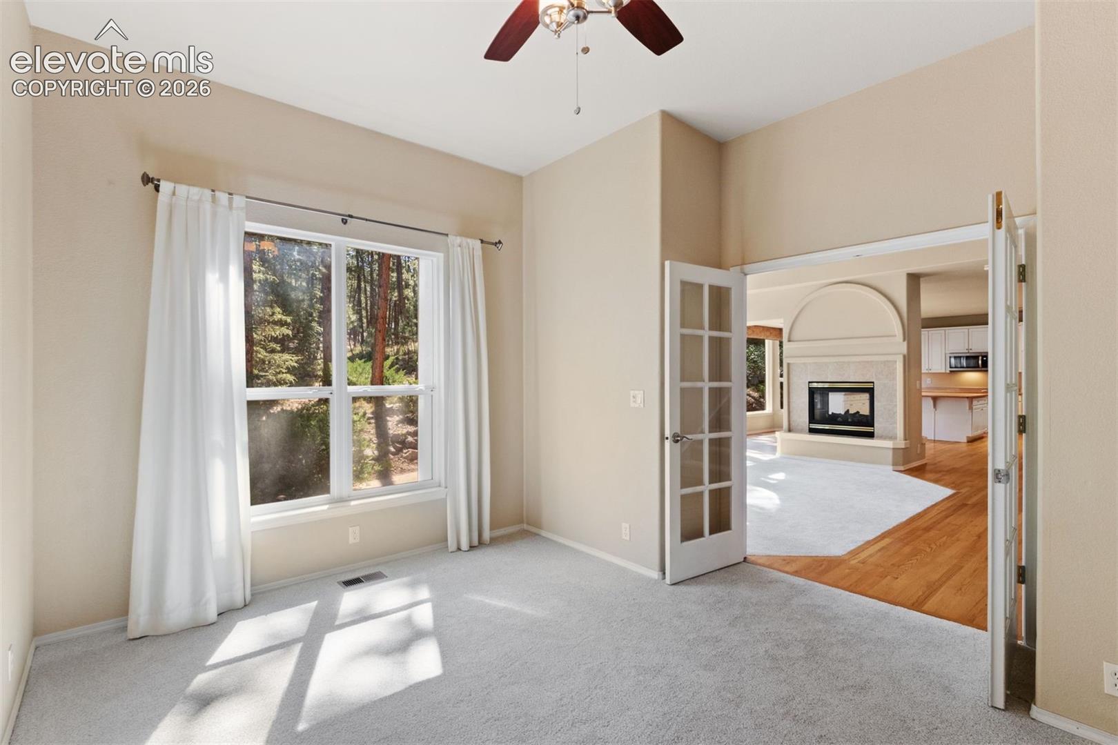 Dedicated main level office with french doors and ceiling fan