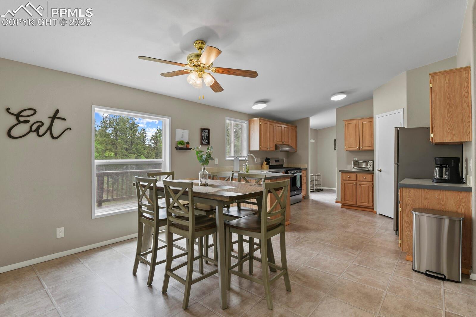 Dining room featuring light tile patterned flooring and ceiling fan