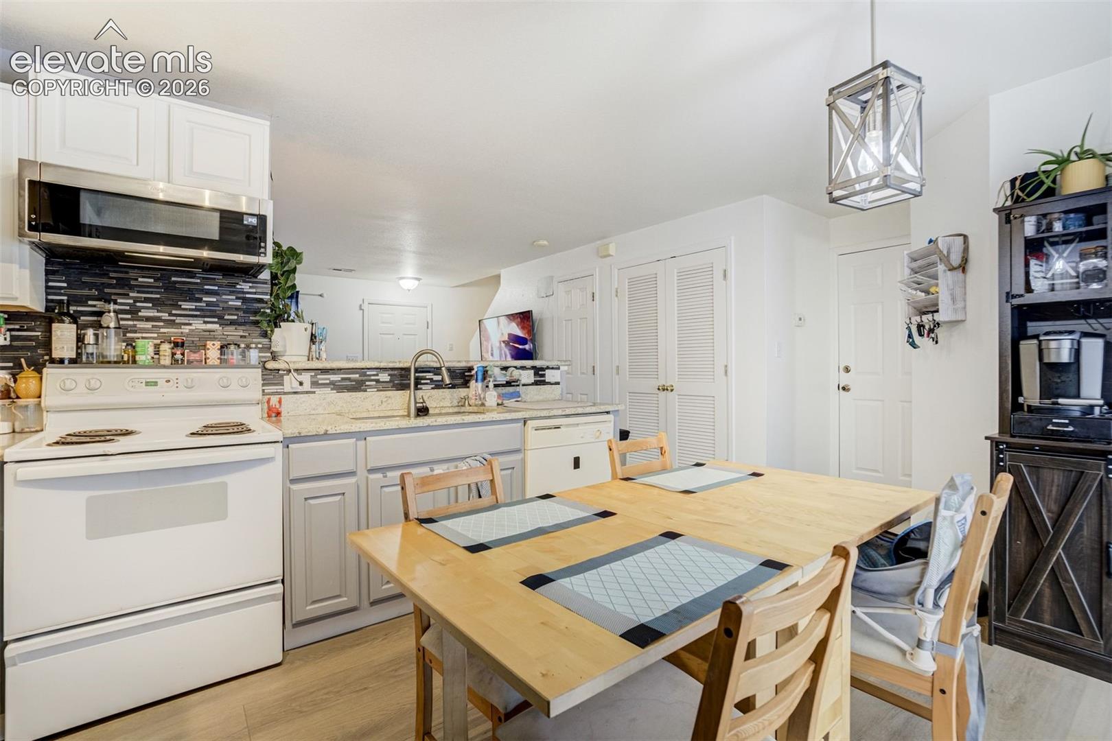 Kitchen featuring white cabinetry, a mosaic tile backsplash, light-colored countertops, and stainless steel appliances