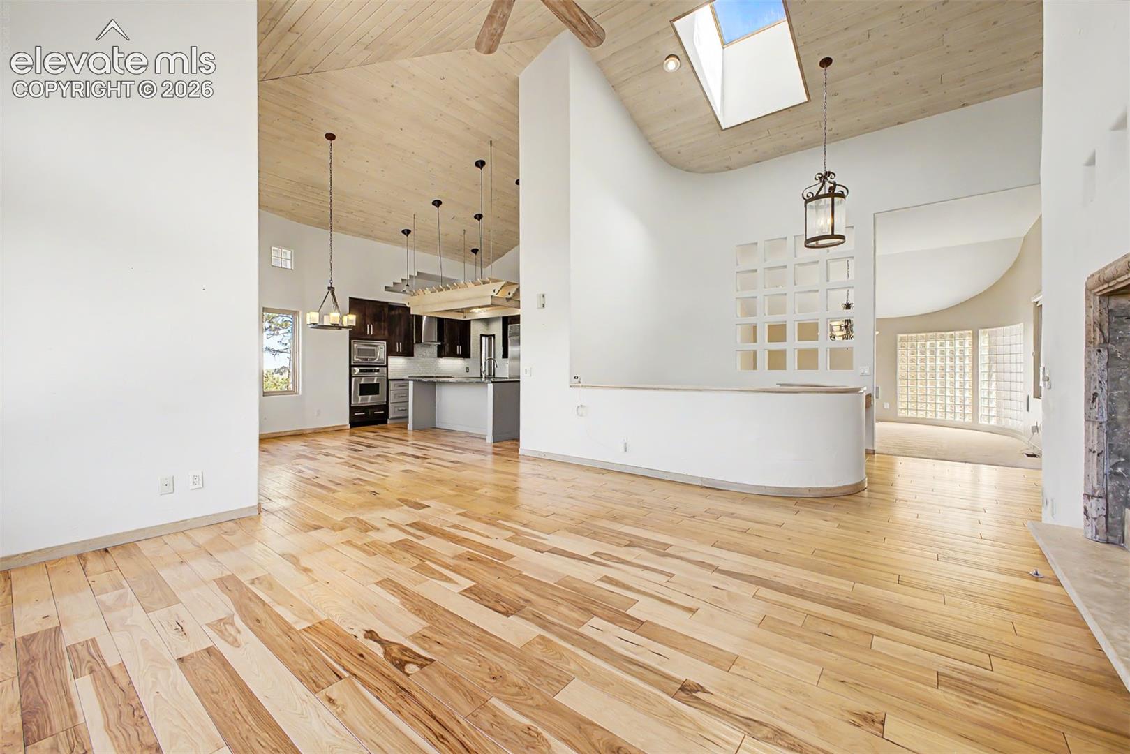 Vaulted wood-paneled ceilings, natural wood-finish flooring, and a skylight