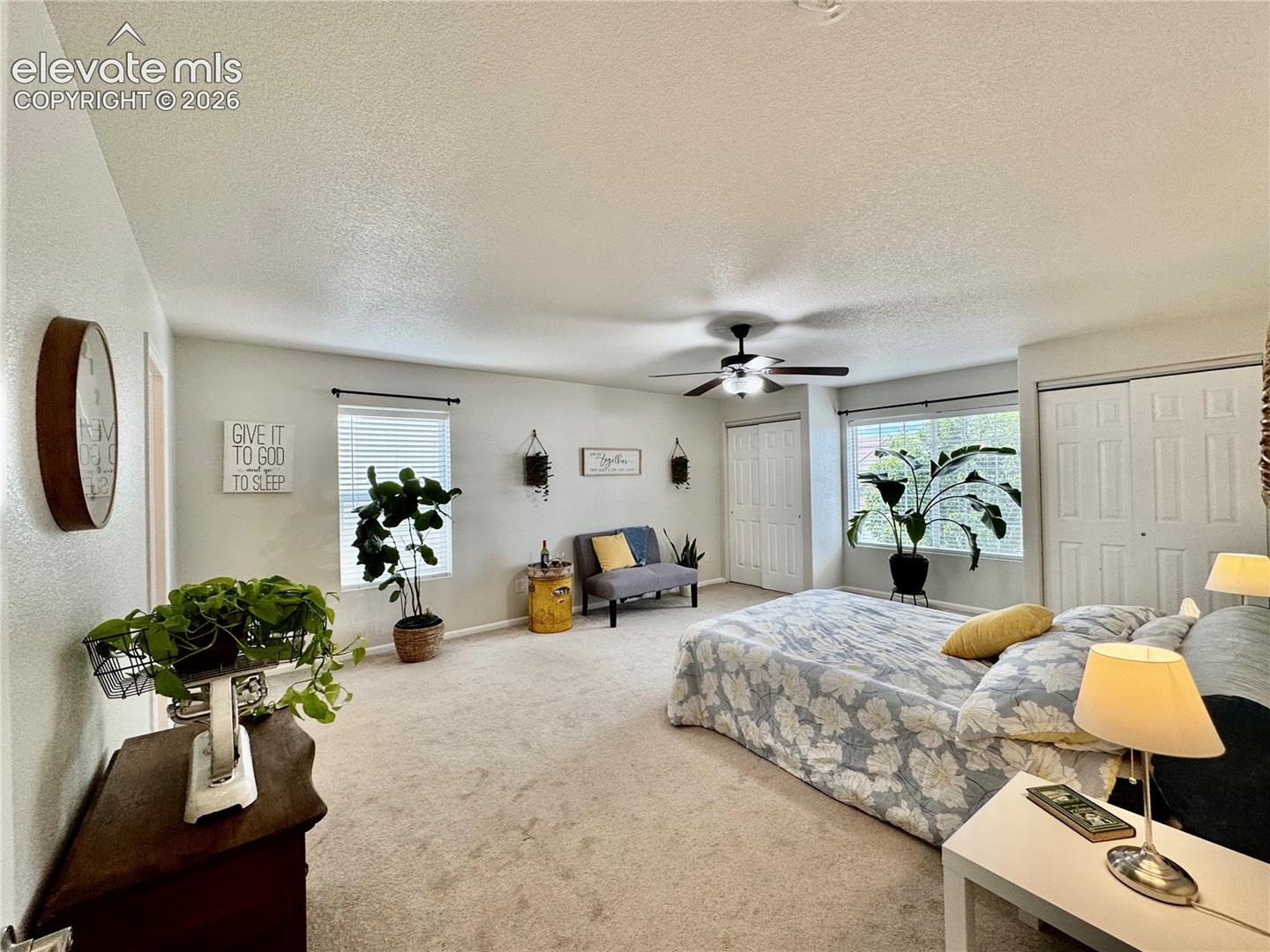 Neutral-toned carpeting and walls complement a ceiling fan with integrated lighting