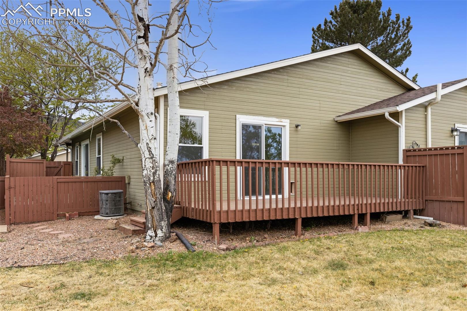 The property features a spacious wooden deck with railings, accessible via sliding glass doors
