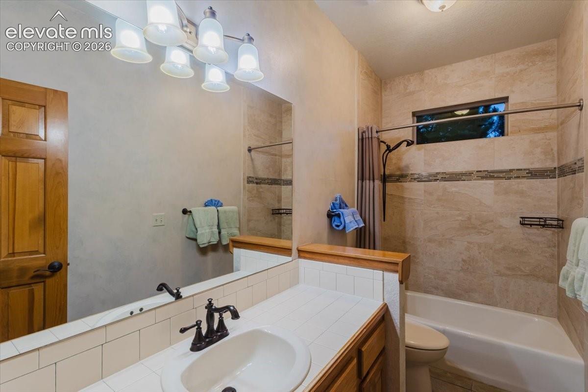 Bathroom with a single vanity, white ceramic tile countertop, oil-rubbed bronze faucet, and a large mirror