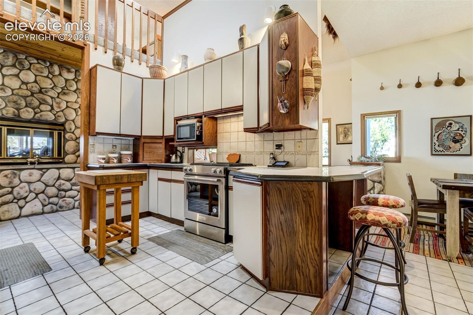 Wood burning, double sided fireplace connect the kitchen to the living room
