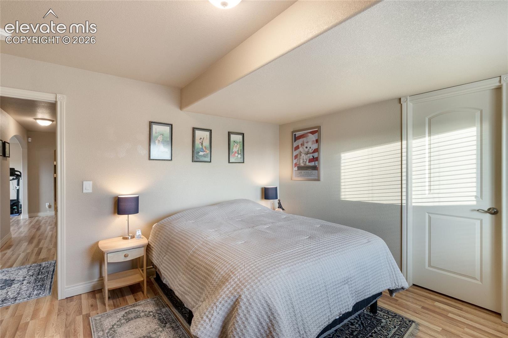 Basement Bedroom with Luxury Vinyl Plank flooring, a solid-core interior door with satin nickel hardware, and recessed ceiling lighting