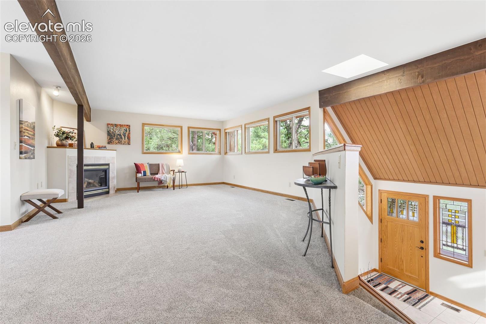 The living room is flooded with light from the abundance of windows.
