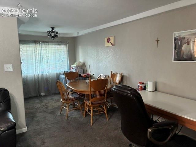 Spacious dining area with wood-finish flooring, neutral wall finishes, and abundant natural light from sliding glass doors