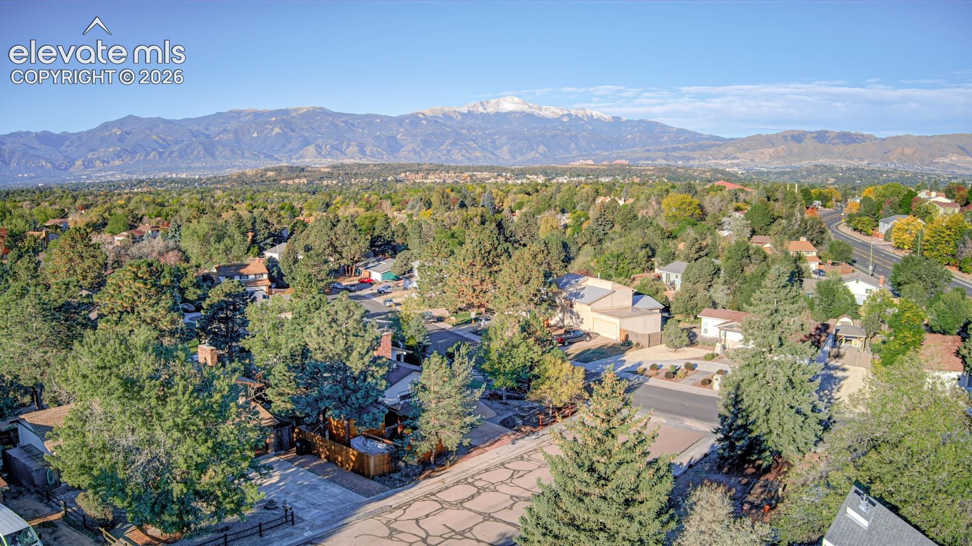 Expansive mountain backdrop with a tree-lined community