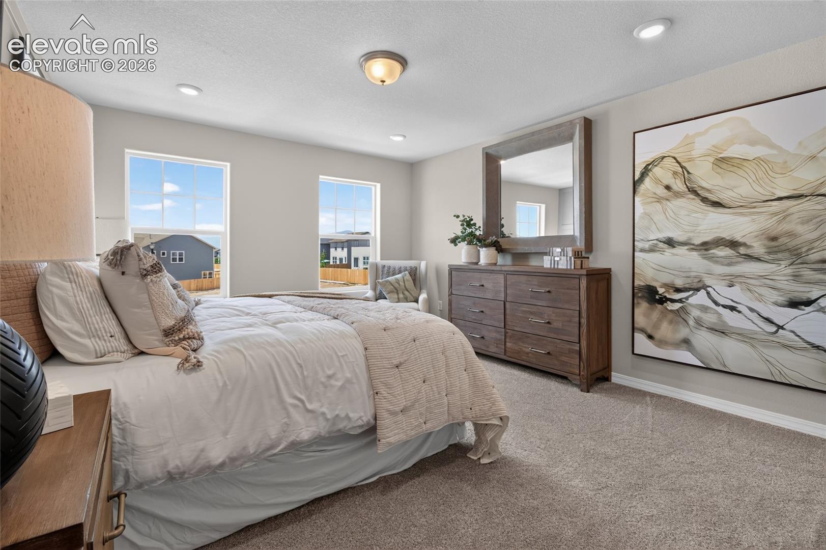 Neutral-toned walls featuring recessed lighting, dual windows with multi-pane glass, and wall-to-wall carpeting