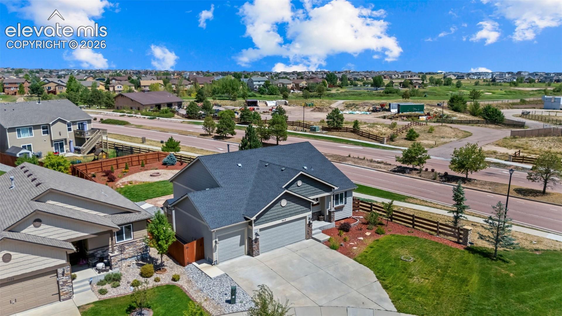 Ranch-style exterior with a two-car garage, concrete driveway, and landscaped front yard