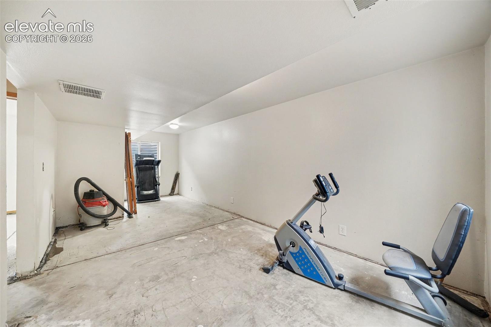 Interior room with neutral wall finishes, concrete flooring, and a window