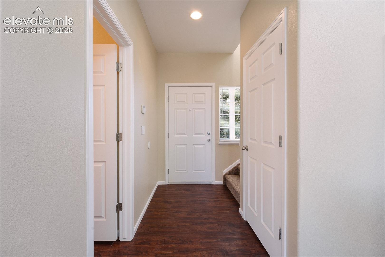 Entryway featuring dark wood-finish flooring, recessed lighting, a multi-pane window, and six-panel interior doors