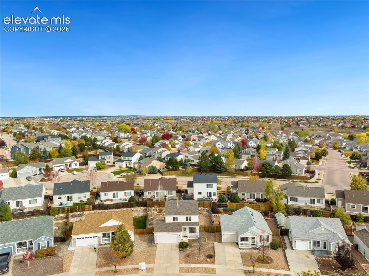 Aerial perspective of a suburban neighborhood featuring single-family residences, concrete driveways, paved street layouts, and established landscaping