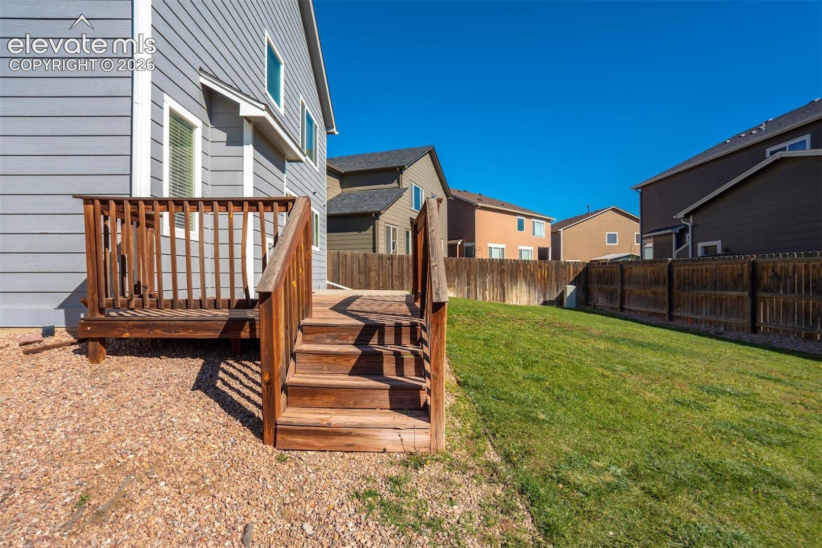 Wooden deck with stairs, graveled area walk to shed