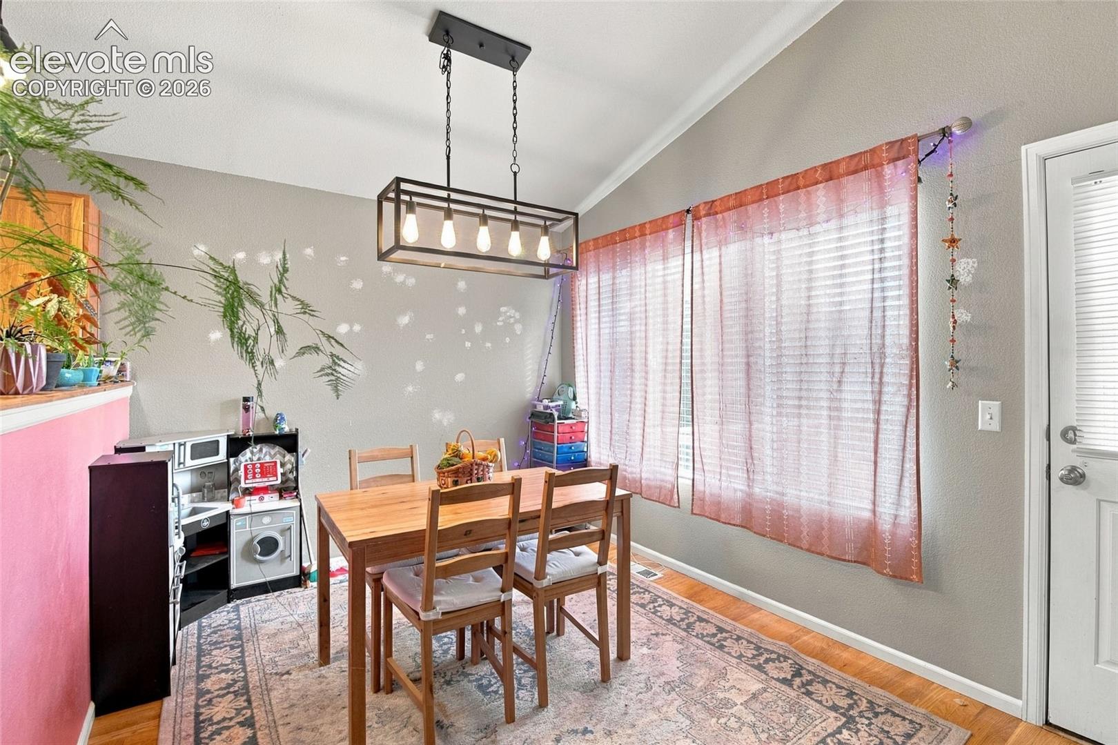 Dedicated dining space w/ updated lighting, a large window, & walkout to deck 