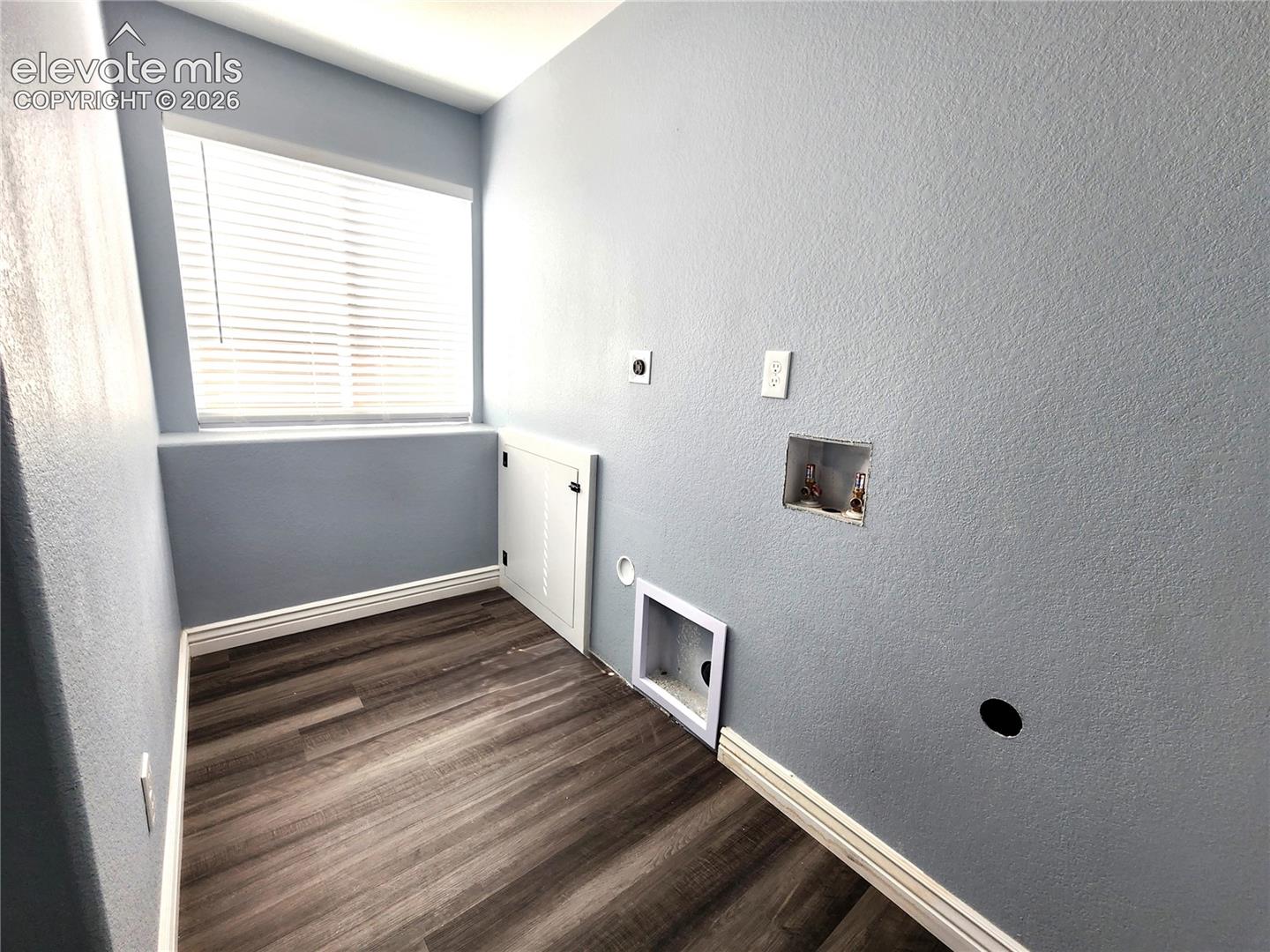 Dedicated laundry room equipped with stylish wood-look flooring