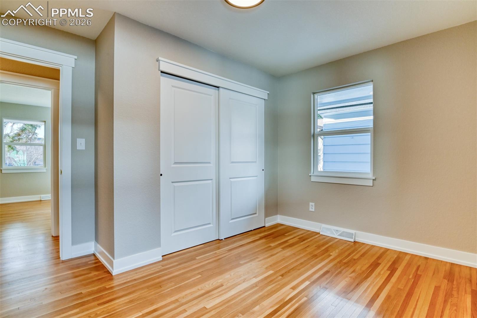 Unfurnished bedroom featuring light wood-style flooring and a closet
