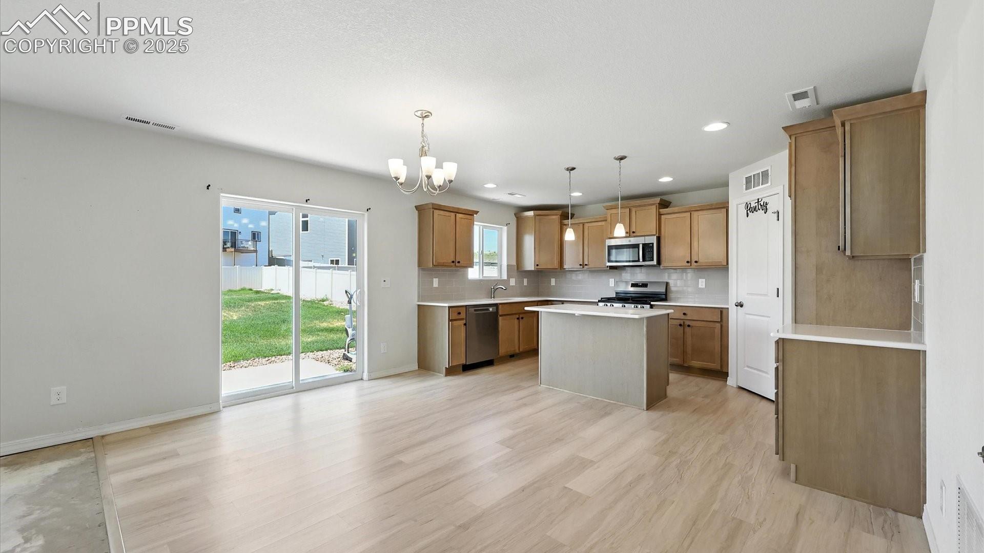 Walk out from the Dining Area and Kitchen to the background patio.